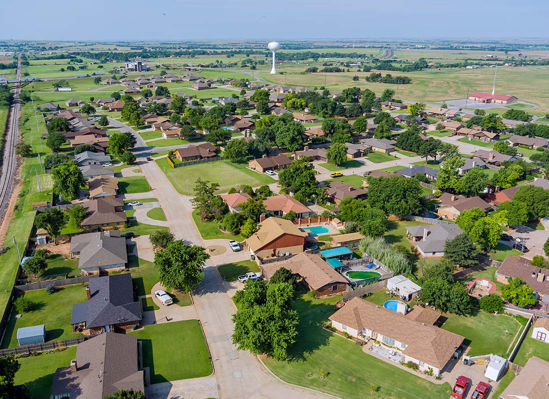 Insurance Solutions - Aerial View of Homes Surrounded by Green Foliage in a Small Town in Oklahoma on a Sunny Day