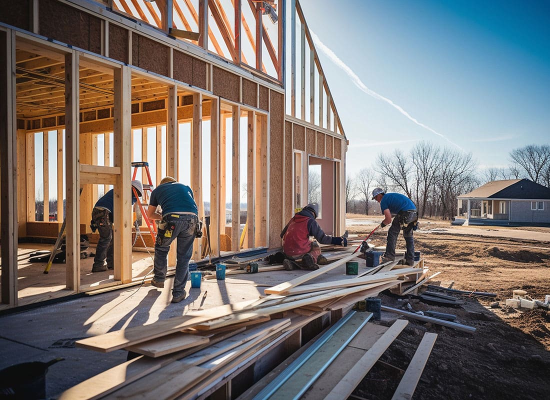 Insurance by Industry - View of a Team of Contractors Building a New House Frame in a Residential Neighborhood on a Sunny Day